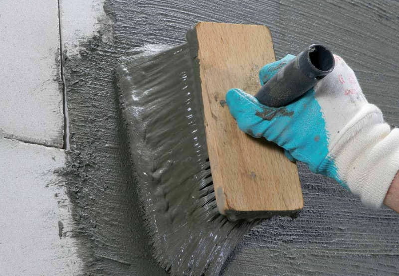 Tanking slurry being applied to wall